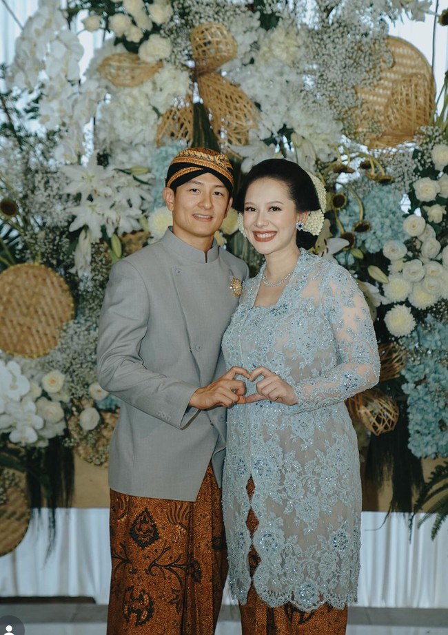 Rio Haryanto dan Athina Papadimitriou tampil serasi dalam balutan busana adat Jawa bernuansa baby blue dan abu-abu di acara Mitoni 7 bulanan kehamilan. Mitoni atau Tingkeban sendiri merupakan tradisi adat Jawa untuk memohon keselamatan dan kelancaran persalinan bagi ibu dan bayi. Foto: Instagram/@rvsdphoto
