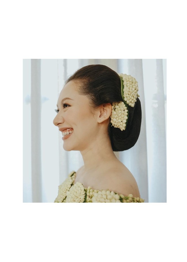 Menambah keanggunan dan nuansa adat, rambut Athina terlihat rapi tersanggul. Sanggul tersebut dipercantik dengan rangkaian bunga melati. Foto: Instagram/@rvsdphoto