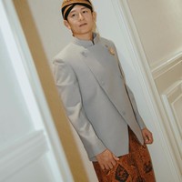 Rio Haryanto tampil gagah kenakan beskap abu-abu dipadukan dengan kain batik coklat sebagai bawahan. Ia juga mengenakan blangkon di kepala yang melengkapi nuansa adat dalam penampilannya. Foto: Instagram/@rvsdphoto