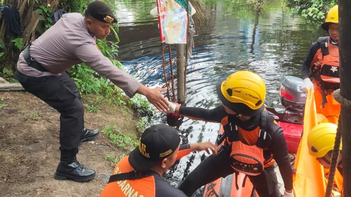 Polisi bersama Tim SAR saat proses evakuasi korban.
