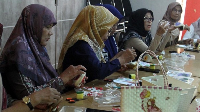 Sejumlah peserta mengoleskan lem saat  pembuatan kerajinan dompet decoupage dalam pelatihan keterampilan ekonomi kreatif di Rumah BUMN Kota Malang, Jawa Timur, Senin (20/7/2026). Pelatihan terapan yang diikuti ibu rumah tangga dan pelaku Usaha Mikro Kecil Menengah (UMKM) tersebut bertujuan meningkatkan kompetensi wirausaha dan keahlian praktis kelompok perempuan di tingkat domestik, guna mendukung akselerasi kemandirian perempuan yang menurut data Kementerian Pemberdayaan Perempuan dan Perlindungan Anak (KemenPPPA) secara nasional mendominasi hingga 64,5 persen dari total pelaku sektor usaha mikro. ANTARA FOTO/Ari Bowo Sucipto/sgd