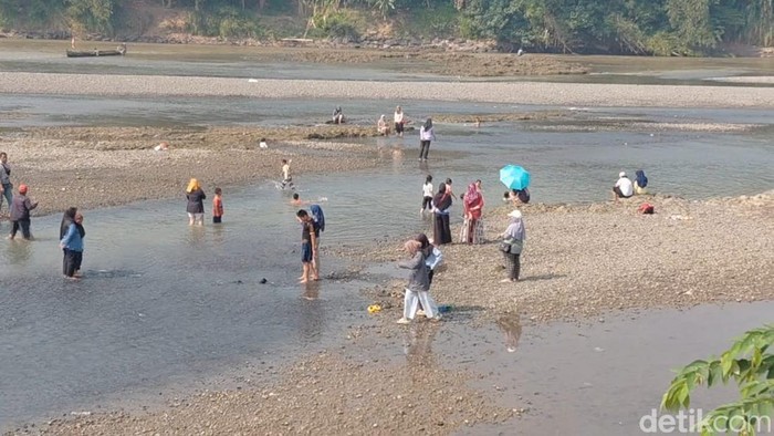 Sejumlah warga berwisata di aliran Sungai Serayu yang surut di Desa Srowot, Kecamatan Kalibagor, Kabupaten Banyumas, Senin (20/7/2026).