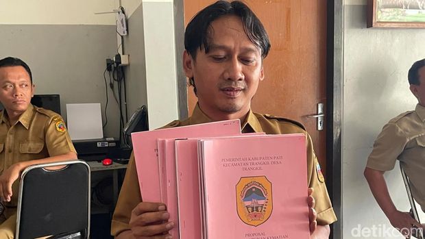 Sekdes Trangkil Bambang Pujianto Sekdes Trangkil, Bambang Pujianto saat menunjukkan proposal pengajuan bantuan sosial kematian, Senin (20/7/2026).