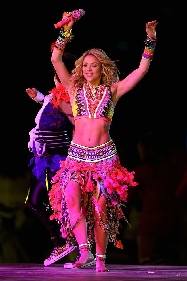 Saat penutupan Piala Dunia 2010, Shakira mengenakan crop top dan rok rumbai berhias bordiran nuansa etnik. Rambutnya dibiarkan tergerai dan ditata bergelombang alami. Foto: Getty Images/Clive Rose
