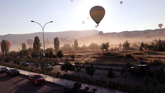 NEVSEHIR, TURKIYE - JULY 21: Hot air balloons float above Cappadocia's distinctive rock formations and fairy chimneys as visitors experience panoramic views of the UNESCO World Heritage-listed region, on July 21, 2026 in Nevsehir, Turkiye. A total of 256,777 tourists took part in hot air balloon tours in Cappadocia during the first six months of the year. Offering bird's-eye views of valleys filled with natural rock formations and fairy chimneys, the balloon rides remain among the most popular activities for domestic and international tourists visiting the region. (Photo by Behcet Alkan/Anadolu via Getty Images)