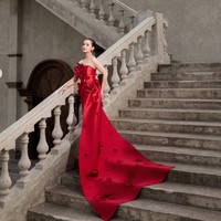 Dea tampil dengan gaun strapless merah dari SIP Studio. Gaun tersebut memiliki siluet yang membentuk tubuh di bagian atas. Sementara bawah gaun dibuat memanjang membentuk train atau ekor yang menjuntai hingga ke lantai. Ekor gaun dihiasi ornamen bunga senada dan membentuk siluet megah, menciptakan efek dramatis. Foto: Instagram/@deaaannisa