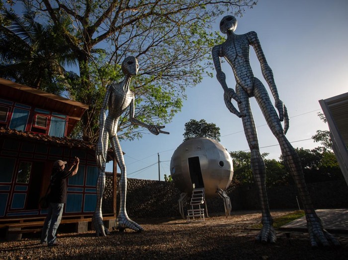 Pengunjung memotret karya yang dipamerkan saat Cosmos Exhibition di Kampung Alien, Nanggulan, Kulon Progo, D.I Yogyakarta, Selasa (21/7/2026). Pameran yang menjadi rangkaian Festival UFO Indonesia 2026 dan berlangsung hingga 31 Juli 2026 itu mengangkat cerita tentang sains antariksa serta eksplorasi luar angkasa. ANTARA FOTO/Andreas Fitri Atmoko/sgd