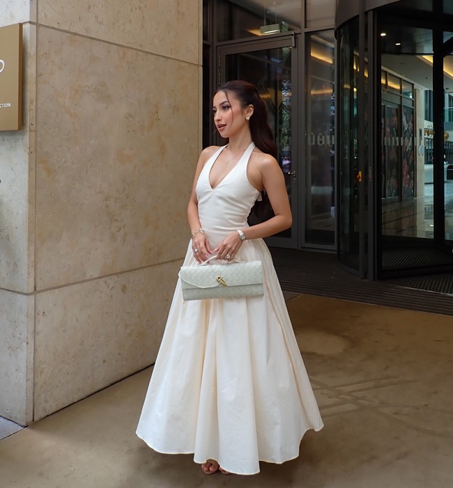 Dress tersebut dipadukan dengan cluch dari merek mewah Bottega Veneta. Cluth dengan model anyaman simpel itu tampak berwarna abu-abu muda, senada dengan busana yang dikenakan. Foto: Instagram/@jenniferhubner