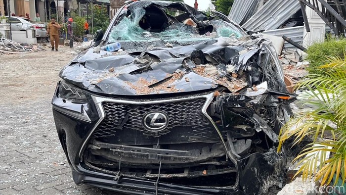 Mobil Lexus yang rusak tertimpa material bangunan.