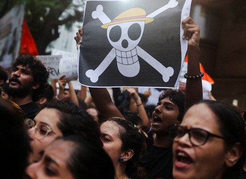 A supporter of the Cockroach Janta Party (CJP) holds a Straw Hat Pirates' Jolly Roger poster from the series One Piece after Sonam Wangchuk was moved by authorities to a hospital during his hunger strike, during a protest demanding the resignation of Indian Education Minister Dharmendra Pradhan, in Mumbai, India, July 19, 2026. REUTERS/Francis Mascarenhas