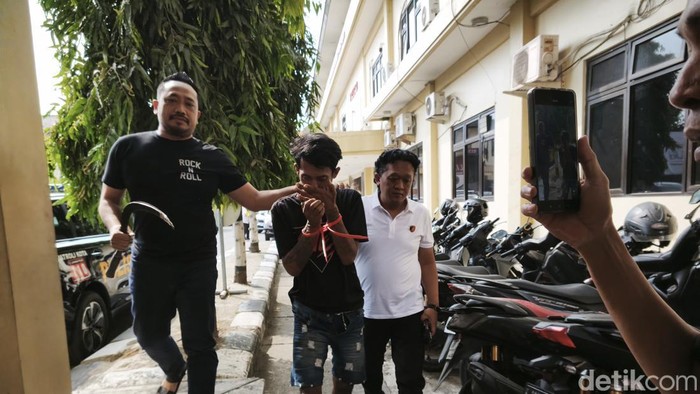 AW, pembacok hingga telinga korban nyaris putus, saat dibawa Unit Resmob Satreskrim Polrestabes Semarang di Mapolrestabes Semarang, Selasa (21/7).