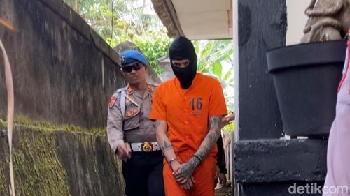 Petong berjalan di lorong gang rumahnya saat melakukan rekonstruksi di Desa Negari, Kecamatan Banjarangkan, Klungkung, Bali, Selasa (21/7/2026). (Fatih Kudus Jaelani/detikBali).