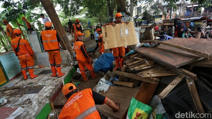 Petugas merobohkan bangunan semi permanen dalam penertiban bangunan liar dan lapak pedagang kaki lima (PKL) di sepanjang bantaran Kanal Banjir Barat (BKB), Jatipinggir, Tanah Abang, Jakarta, Rabu (22/7/2026).