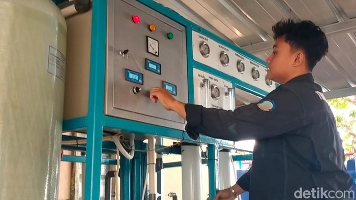 Ahmad Farhani, mengoperasikan mesin penjernih air payau.