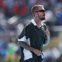 Penampilannya dilengkapi kalung rantai berwarna perak yang diselipkan di balik kerah polo. Meski busananya terlihat sederhana, Justin menyisipkan gaya glamor lewat sepasang anting berlian dari rumah perhiasan mewah Logan Hollowell. Foto: Getty Images/Buda Mendes