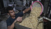 Pekerja memasukkan kedelai ke dalam mesin penggiling di salah satu sentra produksi tahu dan tempe di Ternate, Maluku Utara, Rabu (22/7/2026). Foto: Antara Foto/Andri Saputra