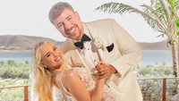 Di momen pernikahan MrBeast tampak gagah mengenakan tuksedo bernuansa putih-hitam, sementara Thea tampil memukau dengan gaun pengantin beraksen renda yang elegan. Keduanya berpose mesra dengan latar pemandangan tropis yang indah. (Foto: dok Instagram mrbeast)