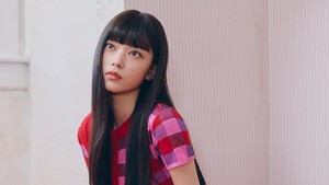 Haerin tampil memesona dengan dress pink dan stocking mawar hitam. (Foto: dok. ADOR)