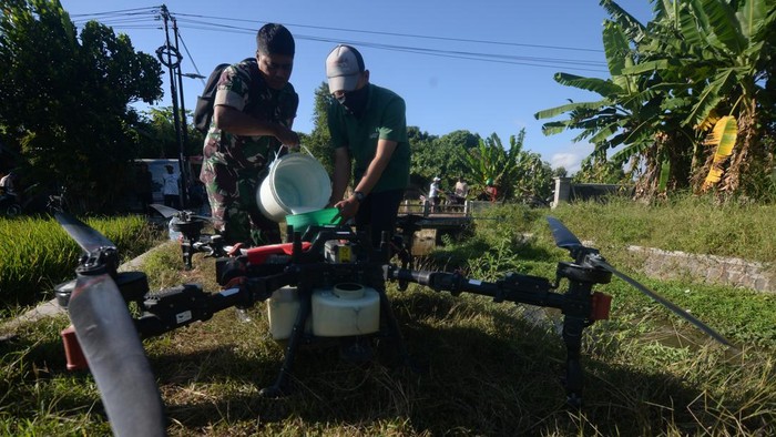 Prajurit TNI membantu memasukkan cairan pestisida ke dalam tangki pesawat tanpa awak atau drone pertanian saat gerakan pengendalian hama terpadu wereng batang coklat di Batan, Banyudono, Boyolali, Jawa Tengah, Rabu (22/7/2026). Penyemprotan pestisida yang dilakukan dengan memanfaatkan teknologi drone secara serentak pada lahan pertanian padi seluas sembilan hektar di wilayah tersebut bertujuan untuk menekan populasi hama wereng batang coklat hingga di bawah ambang pengendalian sehingga dapat menghasilkan padi secara maksimal. ANTARA FOTO/Aloysius Jarot Nugroho/bar