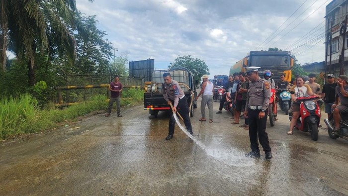 Polisi saat melakukan pembersihan dan evakuasi truk usai terlibat kecelakaan.