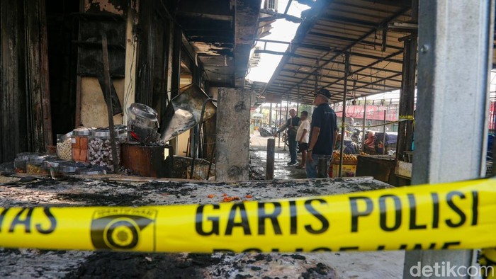 Garis polisi terpasang di depan kios yang terbakar di Pasar Ciputat, Tangerang Selatan, Banten, Kamis (23/7/2026).