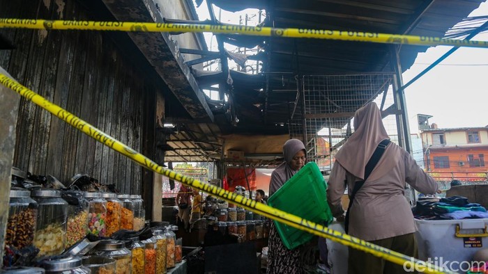 Garis polisi terpasang di depan kios yang terbakar di Pasar Ciputat, Tangerang Selatan, Banten, Kamis (23/7/2026).