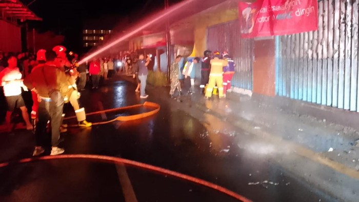 Petugas damkar berusaha memadamkan api yang membakar bengkel motor di Jalan Kapten Tendean Nomor 52, Kabupaten Cilacap, Rabu (22/7/2026) malam.