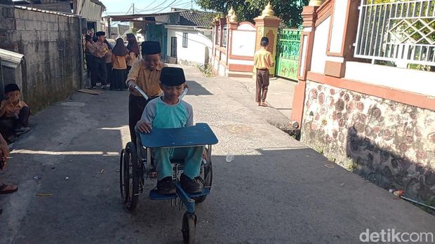 Lalu Aden, bocah kursi roda di Lombok Timur, NTB, bermain bersama teman, Kamis (23/7/2026). (Sanusi/detikBali)