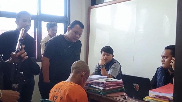 Pelaku yang memerkosa anak kandungnya saat diperiksa polisi.