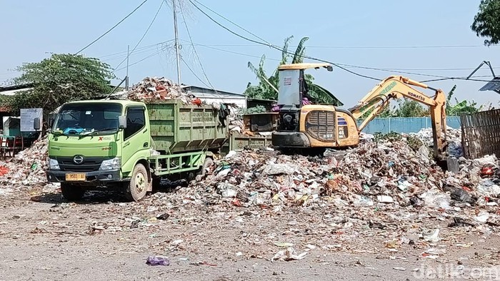 Proses pembersihan gunungan sampah oleh DLH Kabupaten Cirebon di TPS Pasar Batik Weru.
