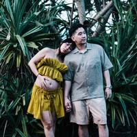 Sang suami, Raka Akmal, mengenakan kemeja lengan pendek berwarna hijau sage bermotif halus yang dipadukan dengan celana pendek krem. Keduanya terlihat kompak dalam balutan busana santai. Foto: Instagram/@adindathomas
