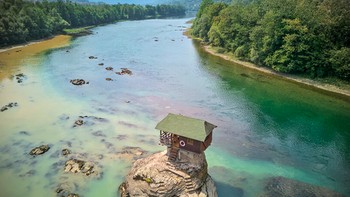 Drina River House di Serbia berdiri di atas batu kecil di tengah Sungai Drina. Pondok kayu mungil ini pertama kali dibangun pada 1968 dan berkali-kali diperbaiki setelah diterjang banjir. Foto: Weird Buildings via DesignBoom