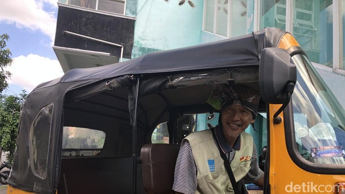 Basuni Yusuf (56) bersama bajaj yang mengantar anaknya kuliah ke ITB, Jumat (24/7).