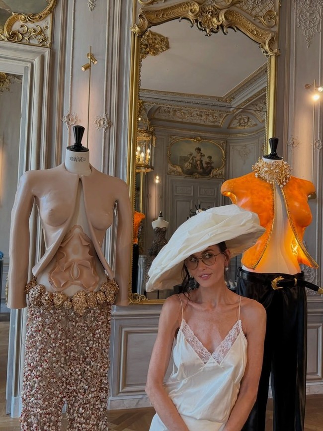 Topi memiliki siluet lembut yang dilipat membentuk awan, sehingga memberi efek dramatis sekaligus melindunginya dari sengatan matahari musim panas Paris. Foto: Instagram/@demimoore