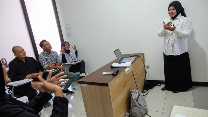 Mahasiswi Universitas Sebelas Maret (UNS) Solo Rizka (kanan) didampingi relawan melakukan presentasi dengan bahasa isyarat saat ujian skripsi di Fakultas Ekonomi kampus setempat, Solo, Jawa Tengah, Kamis (23/7/2026).  Pihak kampus UNS Solo memberikan pendampingan juru bahasa isyarat melalui layanan Forum Relawan Disabilitas (Fordis), guna membantu memfasilitasi kebutuhan mahasiswa disabilitas dalam proses belajar di lingkungan kampus yang inklusif. ANTARA FOTO/Maulana Surya/wsj. *** Local Caption ***