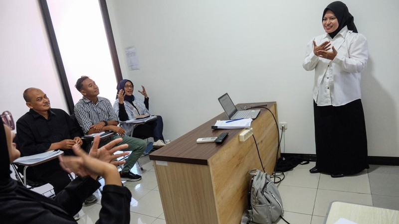 Mahasiswi Universitas Sebelas Maret (UNS) Solo Rizka (kanan) didampingi relawan melakukan presentasi dengan bahasa isyarat saat ujian skripsi di Fakultas Ekonomi kampus setempat, Solo, Jawa Tengah, Kamis (23/7/2026).  Pihak kampus UNS Solo memberikan pendampingan juru bahasa isyarat melalui layanan Forum Relawan Disabilitas (Fordis), guna membantu memfasilitasi kebutuhan mahasiswa disabilitas dalam proses belajar di lingkungan kampus yang inklusif. ANTARA FOTO/Maulana Surya/wsj. *** Local Caption ***