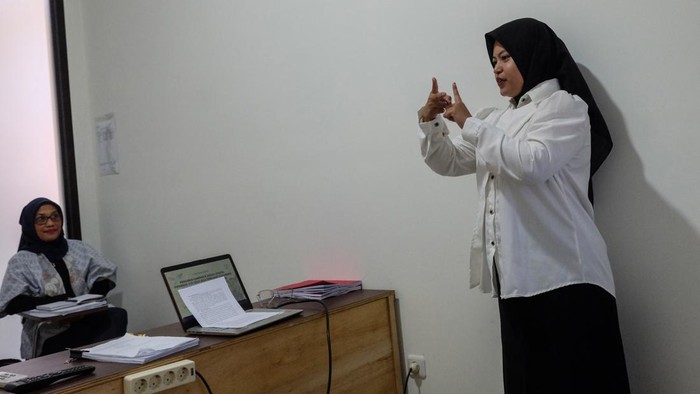 Mahasiswi Universitas Sebelas Maret (UNS) Solo Rizka (kanan) didampingi relawan melakukan presentasi dengan bahasa isyarat saat ujian skripsi di Fakultas Ekonomi kampus setempat, Solo, Jawa Tengah, Kamis (23/7/2026).  Pihak kampus UNS Solo memberikan pendampingan juru bahasa isyarat melalui layanan Forum Relawan Disabilitas (Fordis), guna membantu memfasilitasi kebutuhan mahasiswa disabilitas dalam proses belajar di lingkungan kampus yang inklusif. ANTARA FOTO/Maulana Surya/wsj. *** Local Caption ***