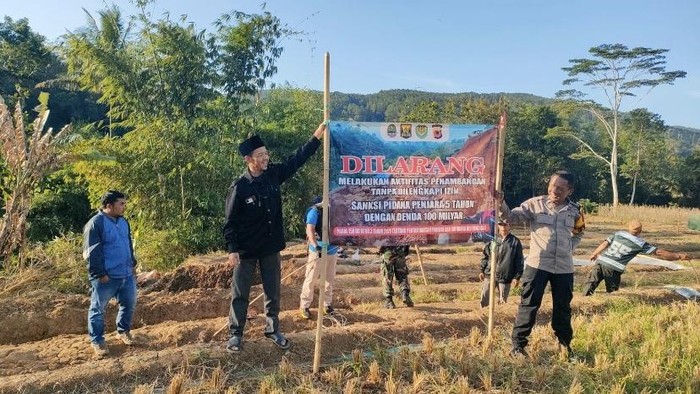 Polisi usai memasang spanduk larangan melakukan penambangan emas ilegal di Sukabumi