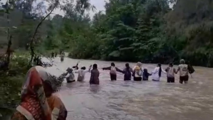 Siswa di Banggai saling berpegangan menyeberangi sungai demi ke sekolah.