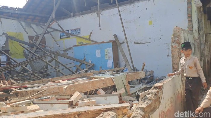 Tampak seorang siswa di antara puing bangunan SDN 2 Tugu yang ambruk.