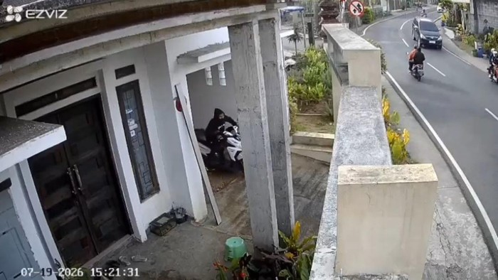 Tangkapan layar rekaman cctv saat pelaku mengeluarkan motor curian dari halaman rumah korban.