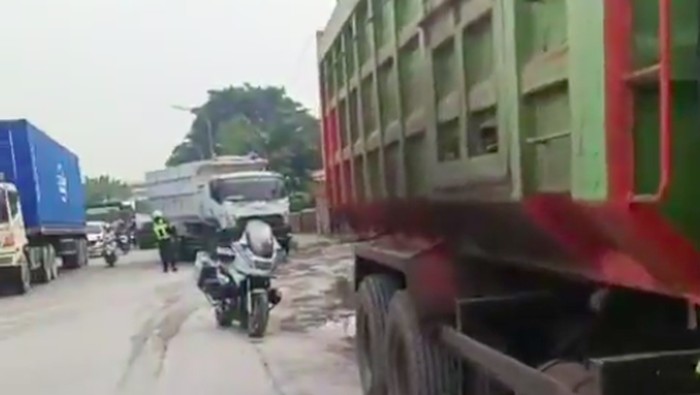 Truk-truk yang parkir sembarangan di tepi Jalan Cakung-Cilincing ditindak petugas karena dapat memicu kemacetan hingga berpotensi terjadi kecelakaan. (dok TMC PMJ)