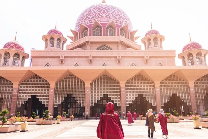Putra Mosque: dress code for female visitors to enter the mosque. They will be ordered to put on a red coat with a hood. It is one of the most visited landmarks in Putrajaya, Malaysia.