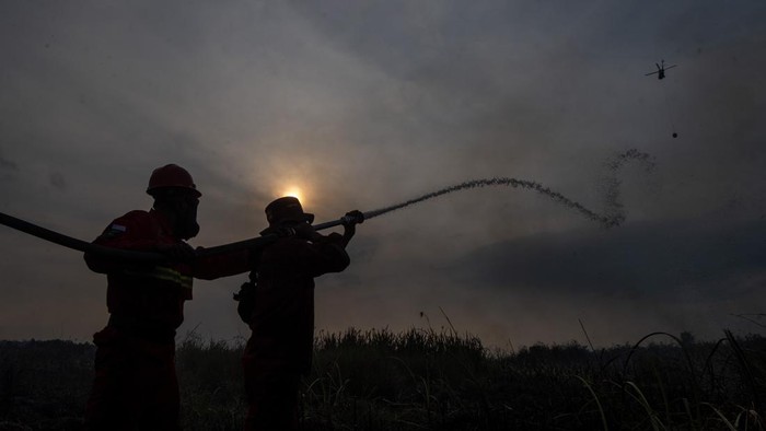 Petugas dari Manggala Agni Daops Sumatera XIV-Banyuasin berusaha memadamkan kebakaran lahan di Desa Sungai Rambutan, Indralaya Utara, Ogan Ilir (OI), Sumatera Selatan, Minggu (26/7/2026). Kebakaran lahan yang terjadi sejak siang hari tersebut tersebut berhasil dipadamkan oleh Manggala Agni Daops Sumatera XIV-Banyuasin dan dibantu oleh Helikopter Water Boombing Sikorsky Black Hawk N 360 UH. ANTARA FOTO/Nova Wahyudi/agr