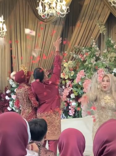 Aksi lempar bunga pernikahan viral setelah ibu pengantin ikut melempar uang tunai, bikin para tamu undangan heboh rebeutan bunga dan saweran.