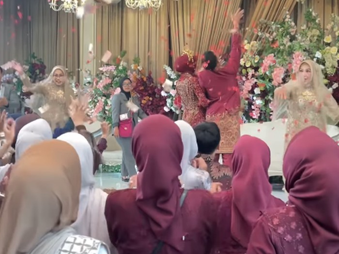 Aksi lempar bunga pernikahan viral setelah ibu pengantin ikut melempar uang tunai, bikin para tamu undangan heboh rebeutan bunga dan saweran.