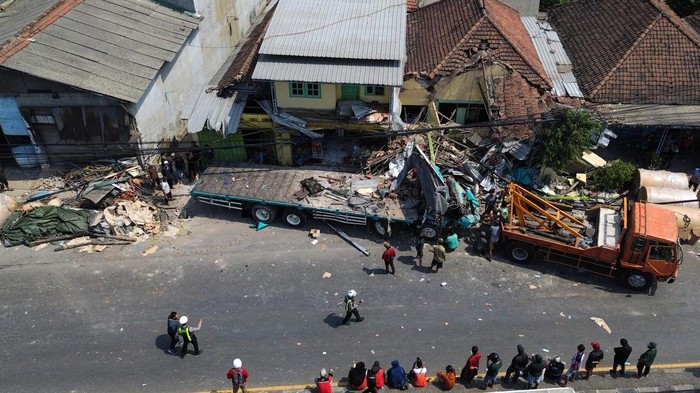 Foto udara warga melihat proses evakuasi truk yang mengalami kecelakaan di Jalan Nasional Surabaya-Malang, Dusun Mojorejo, Desa Ngerong, Kecamatan Gempol, Kabupaten Pasuruan, Jawa Timur, Senin (27/7/2026). Kecelakaan yang terjadi sekitar pukul 06.15 tersebut melibatkan truk bermuatan gulungan kertas menabrak dua truk dan sejumlah sepeda motor serta tujuh rumah mengalami kerusakan yang mengakibatkan empat orang meninggal dunia dan beberapa orang mengalami luka parah dan dilarikan ke rumah sakit. ANTARA FOTO/Umarul Faruq/wsj.