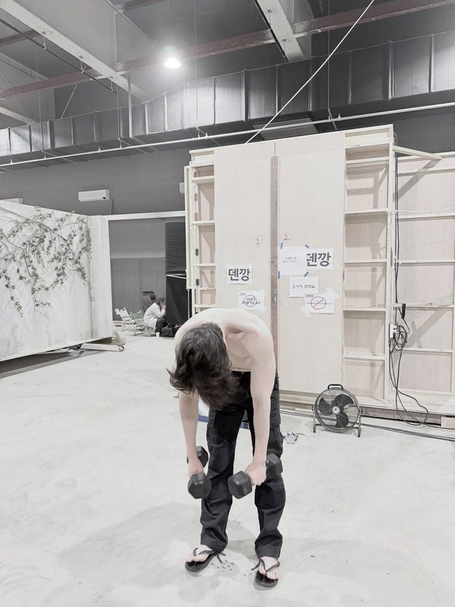 Tampil tanpa atasan, Lee Dong Wook juga menampilkan foto dirinya berolahraga angkat beban di sela-sela syuting A Shop for Killers 2. Foto: Dok. Instagram Lee Dong Wook