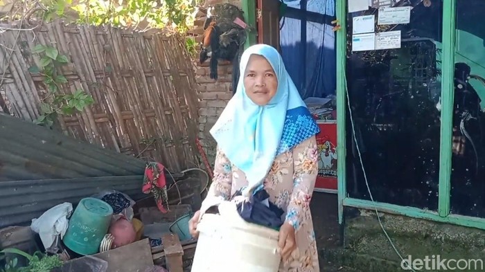 Sukimah sedang melakukan pekerjaan rumah.