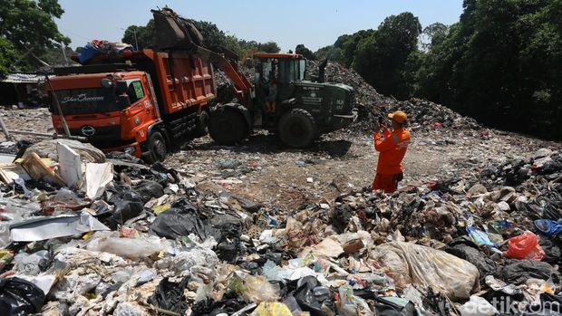 Petugas mengangkut gunungan sampah di Tempat Pembuangan Sampah (TPS) illegal di Jl Kepanduan II, Penjaringan, Jakarta Utara, Senin (27/7/2026). Truk sampah hilir mudik hingga 20 truk sampah per hari. Bau menyengat tercium hingga radius 50 meter tergantung arah angin. Menurut sejumlah warga, lokasi tersebut awalnya merupakan bagian dari ruang terbuka hijau (RTH) namun dimanfaatkan pihak swasta untuk pembuangan sampah hingga banyak pemulung mendirikan gubuk liar untuk mengumpulkan barang bekas. Setelah sampah dibersihkan, lokasi ini akan menjadi RTH kembali.